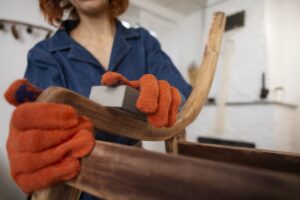 Empresa de carpintería en Valencia - mujer carpintera lijando silla